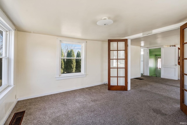 unfurnished room featuring carpet flooring, baseboards, and visible vents