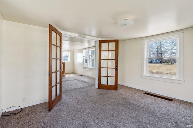 spare room featuring french doors, baseboards, visible vents, and carpet flooring