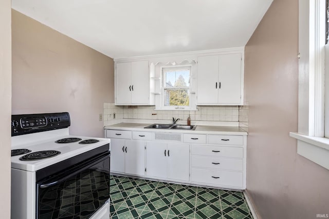 kitchen featuring a sink, white cabinetry, range with electric stovetop, and light countertops