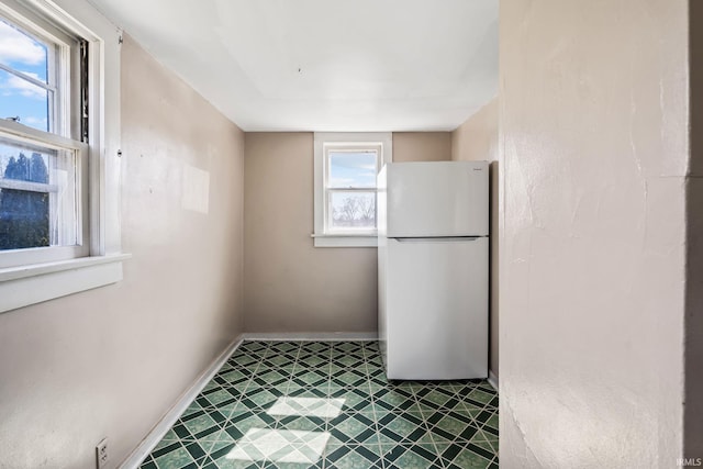 kitchen with tile patterned floors, baseboards, and freestanding refrigerator