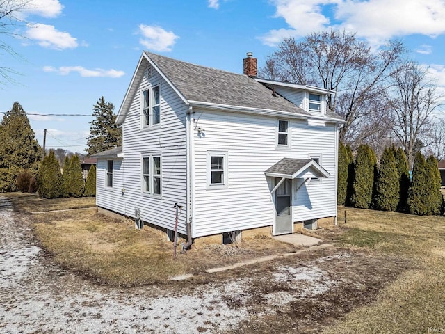 back of property featuring a shingled roof and a chimney