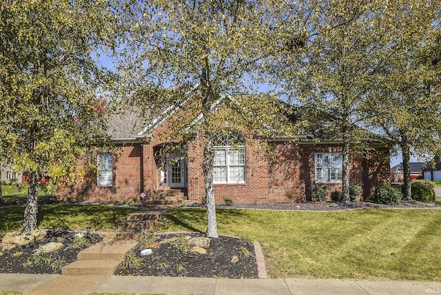 view of front facade featuring brick siding and a front yard