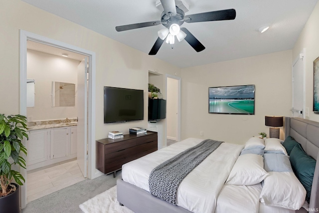 bedroom with a sink, light carpet, ensuite bath, and ceiling fan