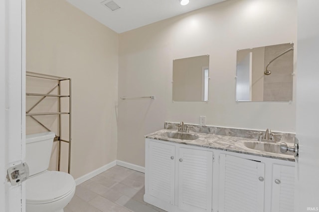 full bathroom with double vanity, toilet, baseboards, and a sink