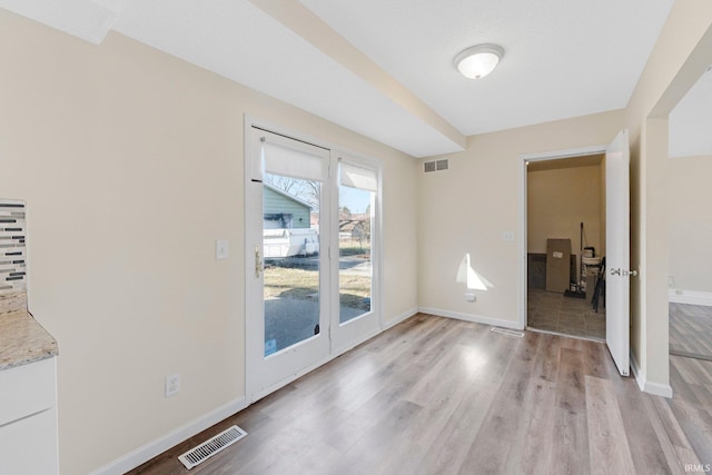 interior space featuring visible vents, light wood-type flooring, and baseboards