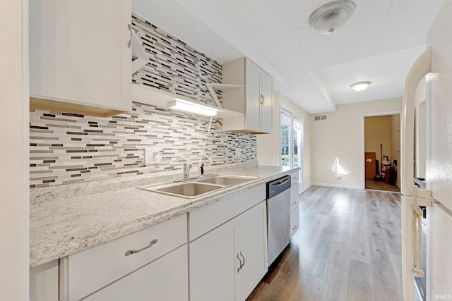 kitchen featuring a sink, open shelves, backsplash, freestanding refrigerator, and dishwasher