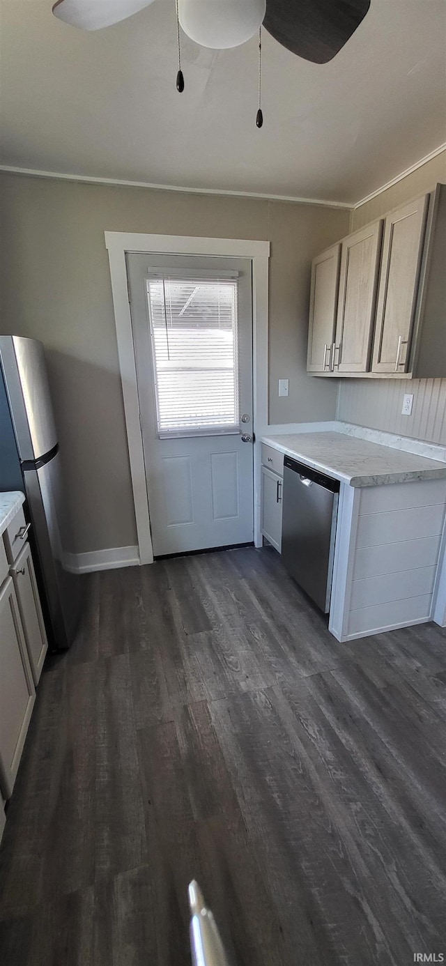 kitchen with dark wood finished floors, appliances with stainless steel finishes, light countertops, baseboards, and ceiling fan