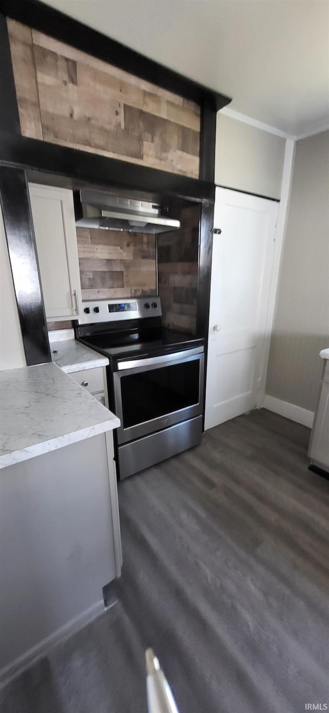 kitchen featuring crown molding, under cabinet range hood, stainless steel electric stove, dark wood finished floors, and white cabinets