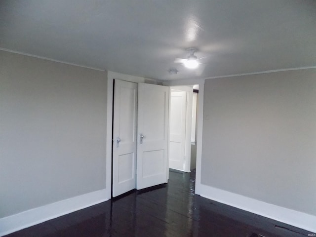 spare room featuring ceiling fan and dark wood-style flooring