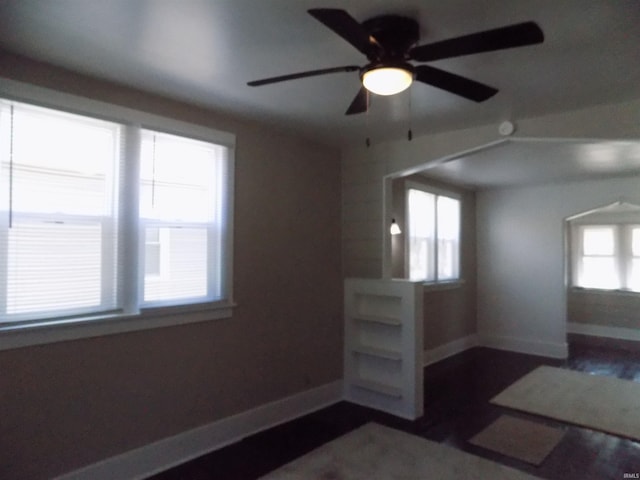 spare room featuring dark wood finished floors, baseboards, and ceiling fan