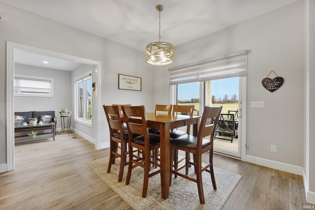 dining space featuring light wood-type flooring, baseboards, and a healthy amount of sunlight