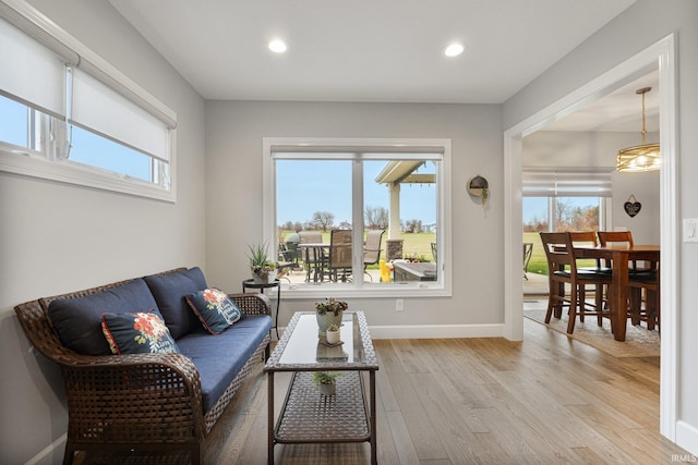 living area with recessed lighting, light wood-style flooring, and baseboards