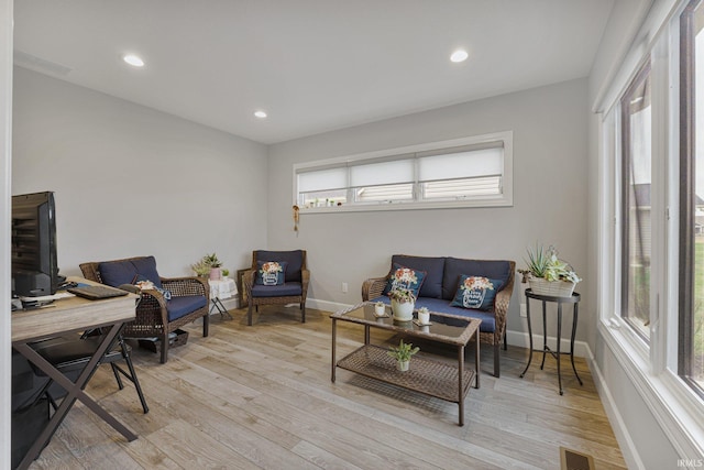 home office with light wood-style floors, visible vents, a wealth of natural light, and baseboards