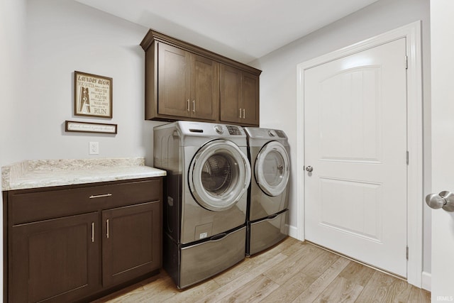 laundry area with cabinet space, washing machine and dryer, and light wood finished floors