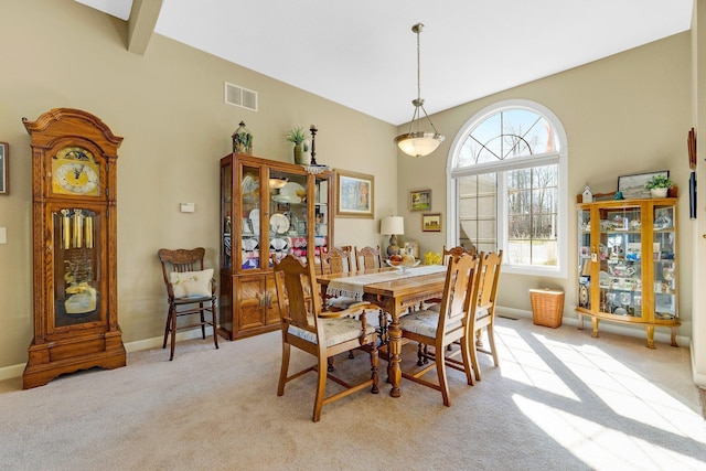 dining room with light colored carpet, visible vents, and baseboards