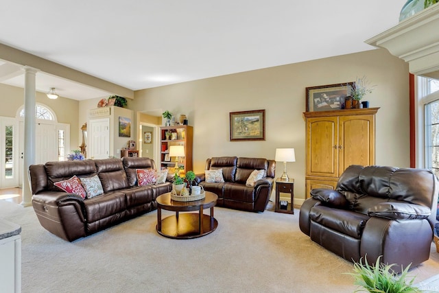 living area featuring decorative columns, baseboards, a wealth of natural light, and light carpet