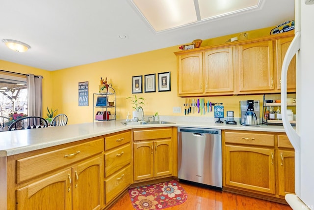 kitchen with dishwasher, a peninsula, light countertops, and a sink