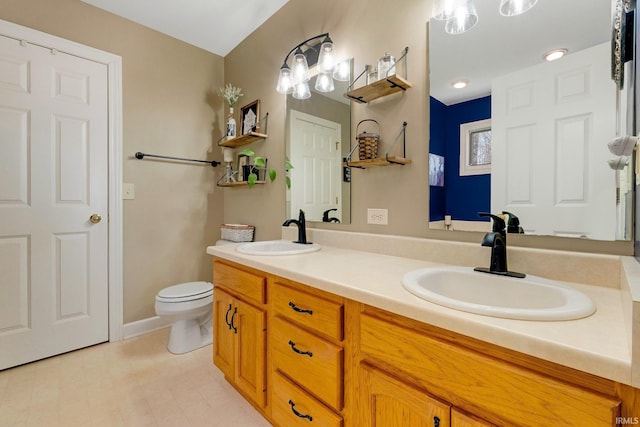 full bath with double vanity, toilet, and a sink