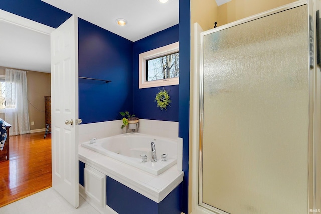 full bathroom featuring a stall shower and a garden tub