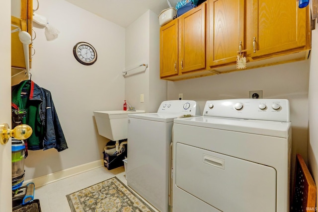 laundry room featuring cabinet space, separate washer and dryer, and baseboards