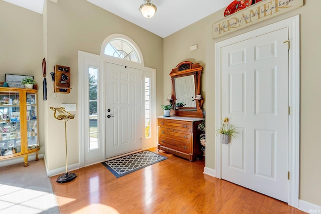 foyer entrance featuring baseboards and light wood-style floors