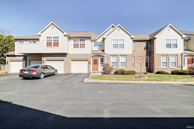 multi unit property featuring a garage and driveway