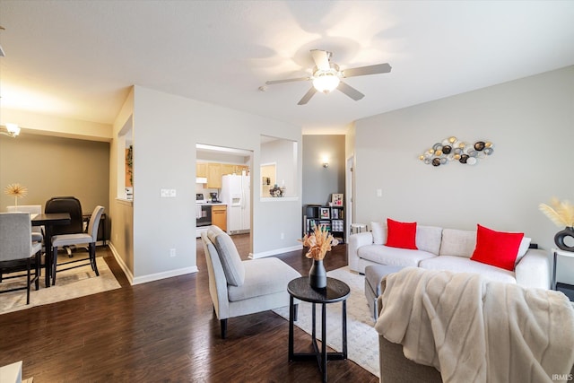 living room with baseboards, ceiling fan, and dark wood-style flooring