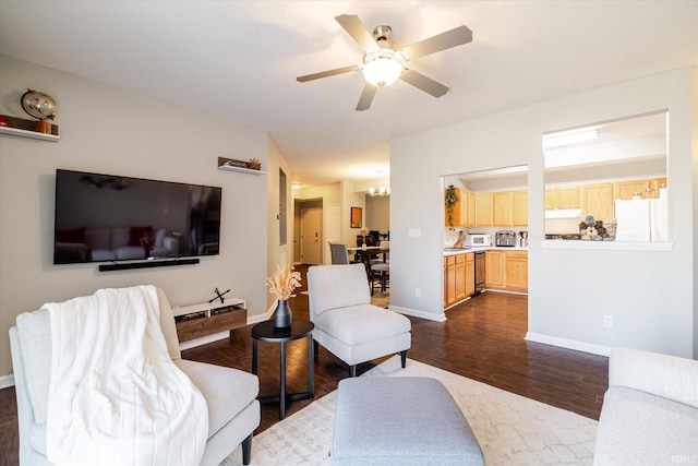 living area with ceiling fan, baseboards, and dark wood-style floors