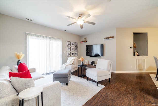 living area featuring dark wood-style floors, visible vents, baseboards, and a ceiling fan