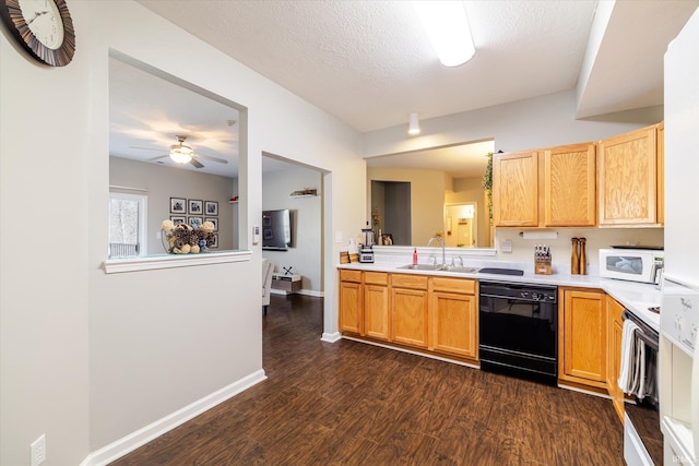 kitchen featuring a sink, dark wood finished floors, light countertops, white microwave, and dishwasher