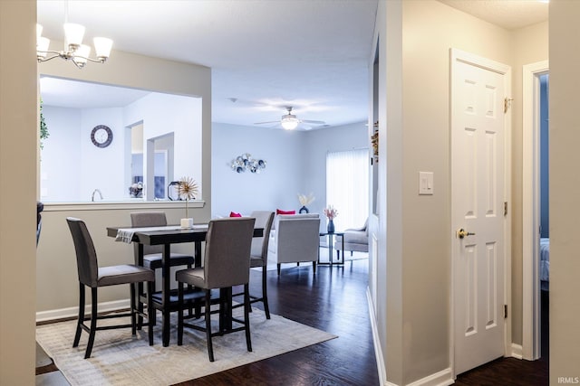 dining room featuring baseboards, dark wood-style flooring, and ceiling fan with notable chandelier