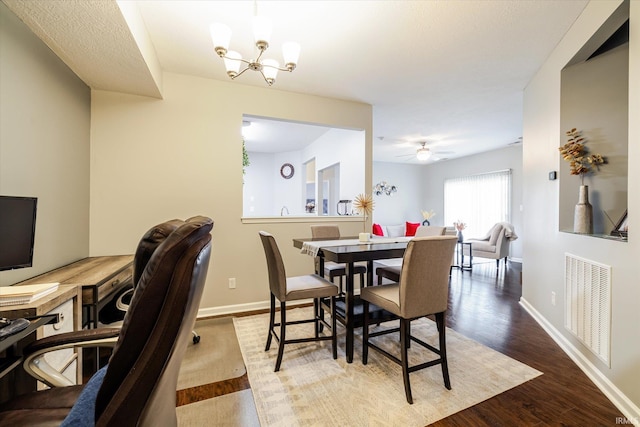 dining space with a notable chandelier, wood finished floors, visible vents, and baseboards