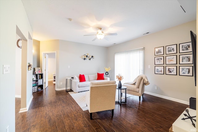 living room with dark wood-style floors, baseboards, and a ceiling fan