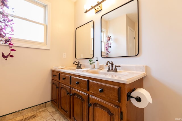 bathroom featuring a sink, visible vents, double vanity, and tile patterned flooring