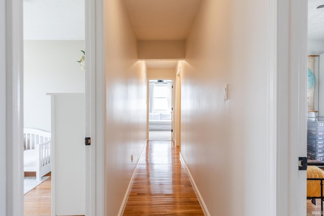 hallway with baseboards and wood finished floors