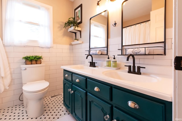 full bath with a sink, toilet, and a healthy amount of sunlight