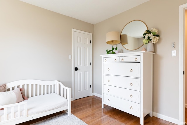 bedroom featuring hardwood / wood-style flooring and baseboards