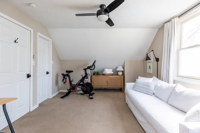 exercise area with vaulted ceiling, a ceiling fan, baseboards, and light carpet