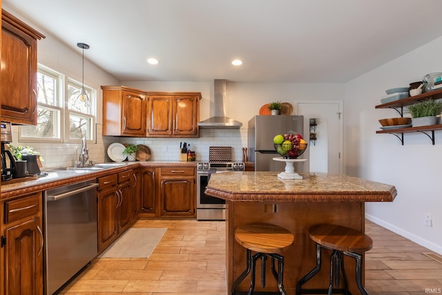 kitchen featuring backsplash, appliances with stainless steel finishes, a kitchen island, and wall chimney exhaust hood