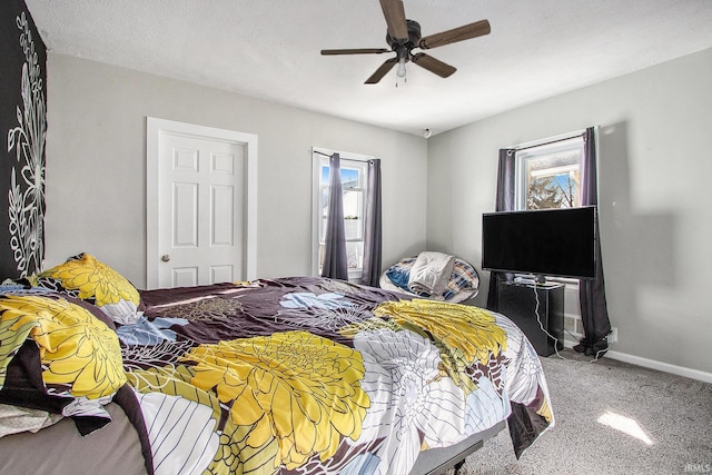 carpeted bedroom featuring baseboards and a ceiling fan