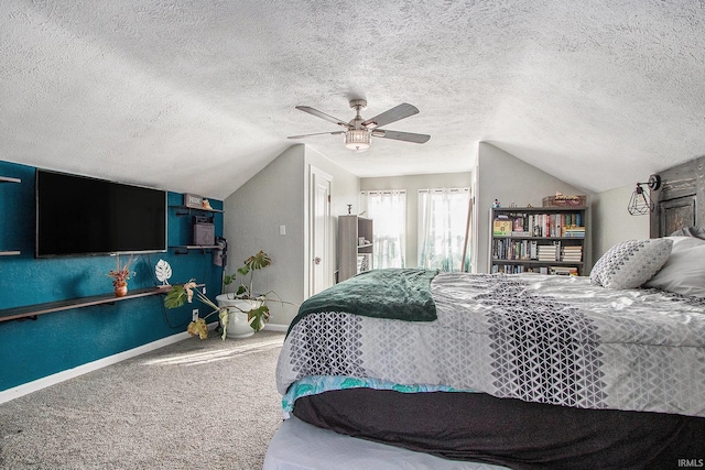 bedroom featuring lofted ceiling, baseboards, carpet floors, and a textured ceiling