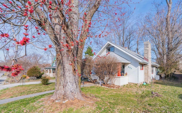 view of front of home with a chimney and a front yard