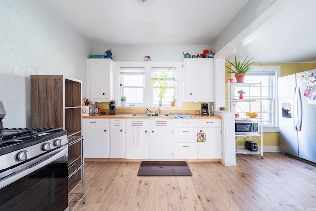 kitchen featuring plenty of natural light, light wood-style floors, appliances with stainless steel finishes, and a sink