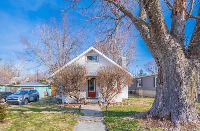 view of front of property featuring a front yard, a porch, and a chimney