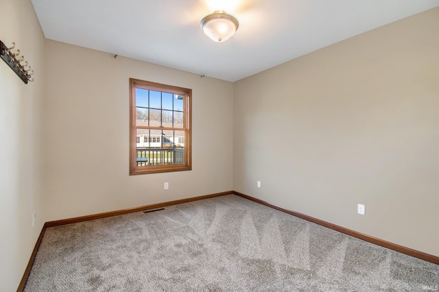 empty room with visible vents, baseboards, and carpet floors