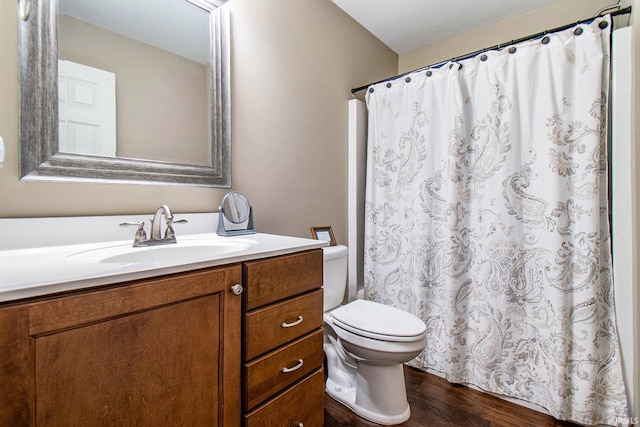 bathroom with curtained shower, toilet, vanity, and wood finished floors