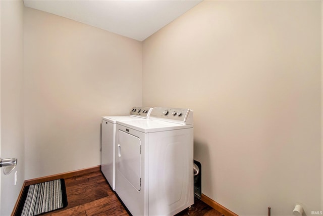 clothes washing area with baseboards, independent washer and dryer, dark wood-style flooring, and laundry area