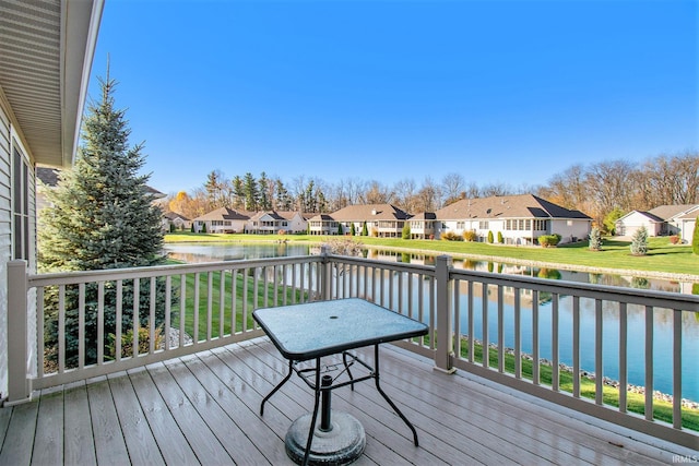 wooden deck featuring a lawn, a residential view, and a water view