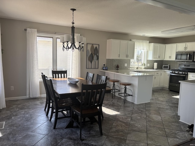 dining area featuring baseboards, plenty of natural light, a notable chandelier, and visible vents