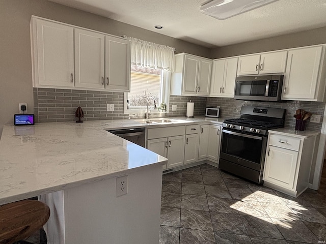 kitchen featuring white cabinets, appliances with stainless steel finishes, and a sink